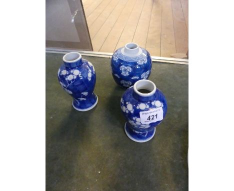 A Chinese blue and white prunus tea caddy and cover, having six character mark to base, together with a pair of prunus vases,