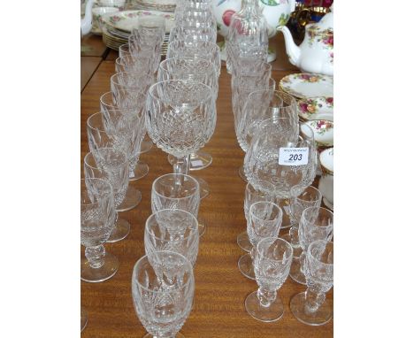 A suite of Waterford crystal tablewares to include a decanter with golf ball shaped stopper, tumblers, brandy blooms, wine go