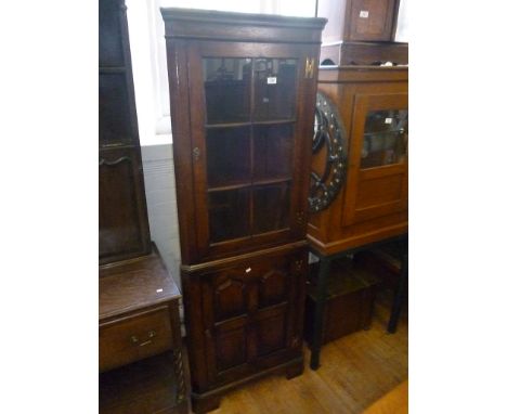 A good quality reproduction mid 18th Century style oak two section freestanding corner cupboard, the upper section with glaze