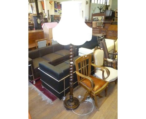 An early to mid 20th Century oak standard lamp, with barleytwist decoration terminating in a circular support.