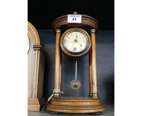 An early 20th Century mahogany portico clock, with a gilt metal fruit finial.