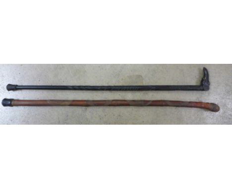 A Japanese carved walking cane and a carved ebony walking stick 