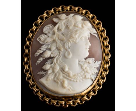 An oval shell cameo portrait brooch: depicting a classical woman, within a circular-link frame, the reverse stamped '9C' appr