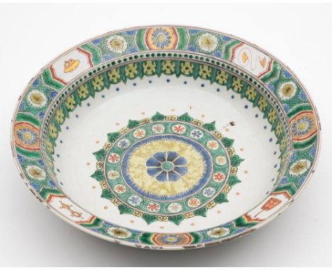 A Chinese famille verte bowl: with flattened rim, painted with a central floral medallion within foliate, ruyi-head and dot b