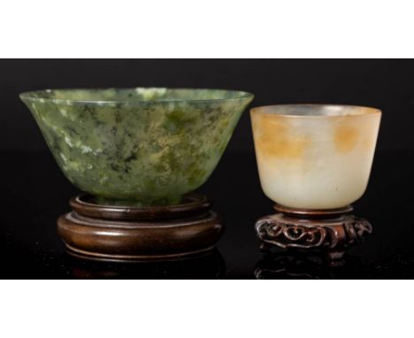 A Chinese jadeite bowl and one other: the first with flared rim, the stone flecked with cream and grey inclusions, 10cm diame