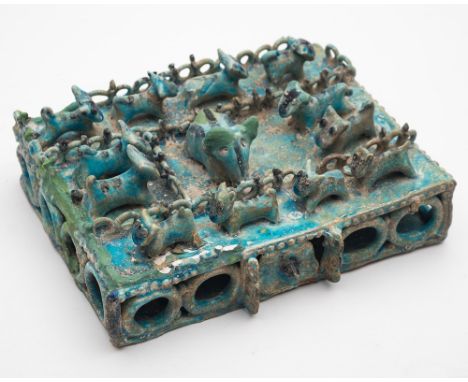 An unusual turquoise glazed tile: probably Iranian modelled in the form of a fenced rectangular compound containing numerous 