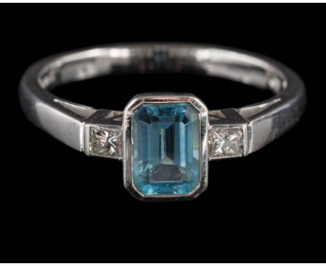 An 18ct white gold, aquamarine and diamond ring: the emerald-cut aquamarine in rub-over setting set between princess-cut diam