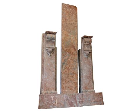 A peach variegated marble fireplace:, the moulded shelf with cut corners and with plain frieze and pilasters headed with scro