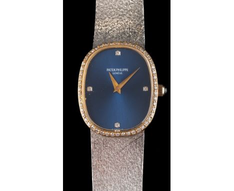 Patek Philippe. A lady's two colour 18ct gold and diamond mounted manual wind wristwatch: the dark blue, cushion-shaped dial 