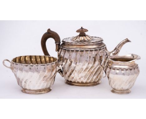 A Victorian silver three-piece tea service, maker Edward Brown, London, 1880/81: of oval outline with fluted writhen decorati