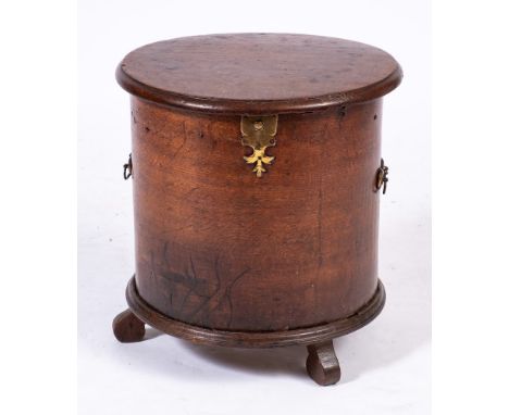 An 18th Century oak drum shaped commode:, with a hinged moulded top and interior cover, the sides with brass carrying handles
