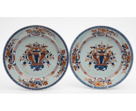 A pair of Chinese Imari dishes:  each painted in underglaze blue, iron-red and gilt with a central vase of flowers flanked by