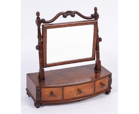 A late Regency mahogany swing frame platform toilet mirror: the rectangular plate with scroll and roundel decorated cresting 