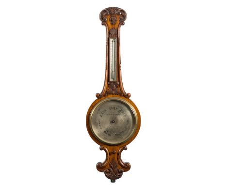 Negretti and Zambra, London, an oak wheel barometer: the ten-inch round white enamelled dial with usual barometer markings an