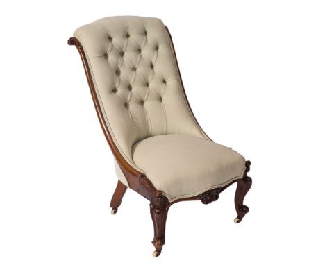 A Victorian carved walnut nursing chair:, with curved upholstered button down back and serpentine stuff over seat, with folia