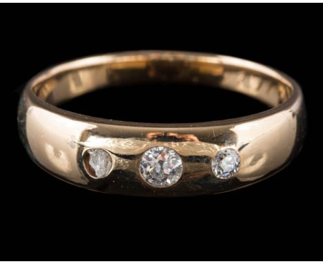 A gold and three-stone diamond band: with graduated old-cut diamonds estimated to weigh a total of 0.20ct, ring size R. 