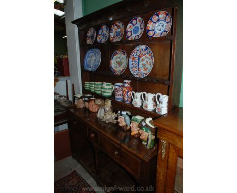 A Georgian Oak Potboard Dresser with plate rack, moulded cornice and the three shelf rack with iron cup hooks and wide back b