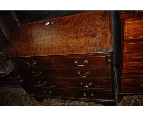 A Georgian Oak Bureau having plain top, the fall with cleated ends and moulded edge opening to reveal eight pigeon holes, two