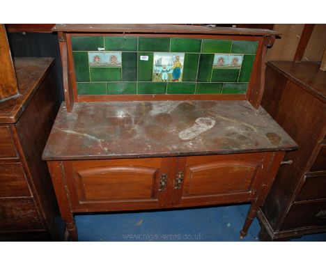 An art nouveau Washstand, with upper shelf to the tiled back, on shaped bracket supports, the tiled back being green tiles wi