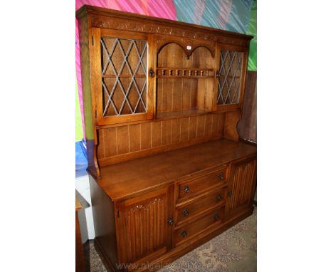 A good reproduction Oak Dresser, having moulded cornice to the top, over carved frieze over central carved apron, over flight