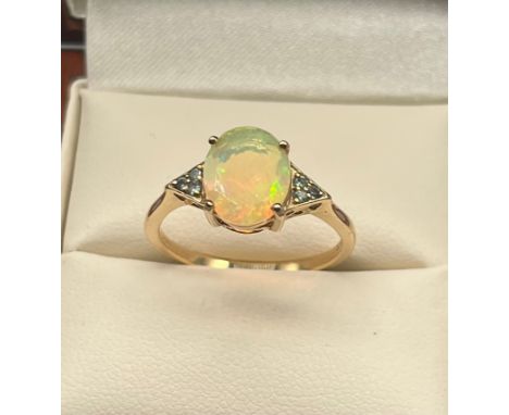 10CT Yellow gold ladies ring set with An Ethiopian opal stone off set by green Spinel Stone shoulders. [Ring size P] [2.26Gra