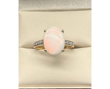 10ct yellow gold ladies ring set with a large opal stone off set by white topaz stone shoulders. [Ring size P] [2.59Grams] 