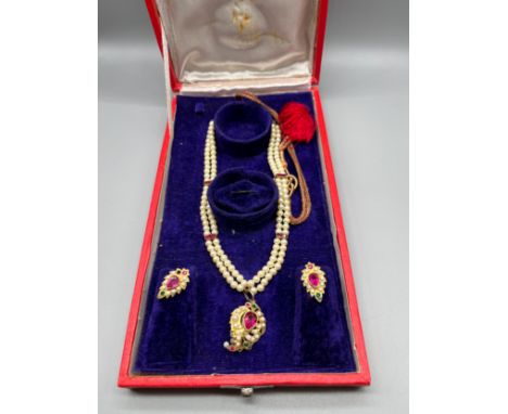 Antique/ Vintage Indian gold pendant fitted with a large ruby stone off set by pearls and green glass stones, Fitted with a p