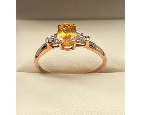 9ct rose gold ladies ring set with an orange stone and off set by clear stones. [Ring size R] [1.63Grams] 