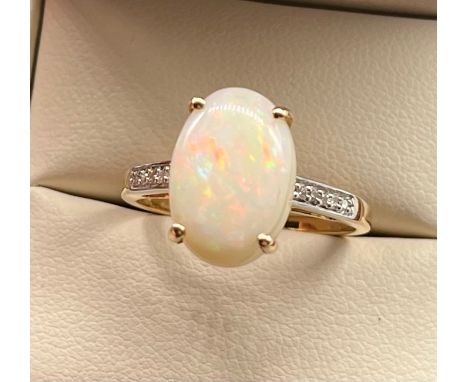 14ct yellow gold ladies ring set with a large opal stone off set by diamond shoulders. [Ring size R] [3.91Grams] 