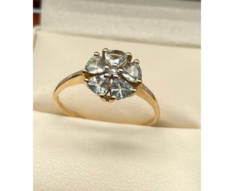 9ct yellow gold ladies ring set in a flower design using a single white spinel stone of set by Aquamarine stones. [Ring size 