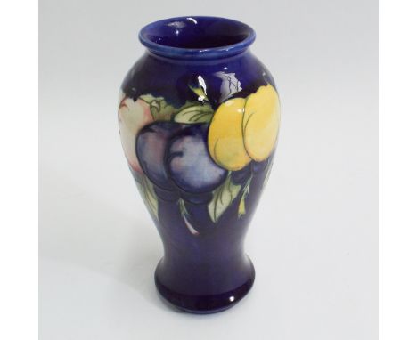 Moorcroft pottery vase decorated with lemons and plums, blue ground, signed to the base.  19cm high  In good condition - no a