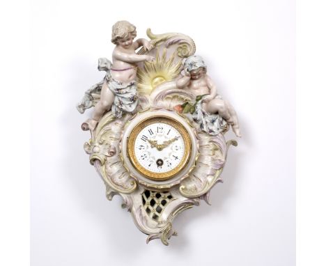 A LATE 19TH CENTURY DRESDEN PORCELAIN WALL CLOCK, surmounted by two cherubs, and with gilt heightened and florally painted de