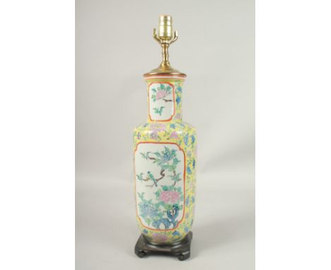 A CHINESE YELLOW GROUND PORCELAIN LAMP on a wooden base. 56cms high.