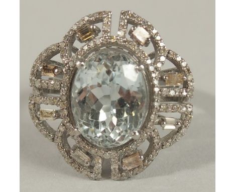AN ORNATE DRESS RING in silver, set with an oval aquamarine surrounded by baguette and R/C diamonds in a filigree mount, boxe