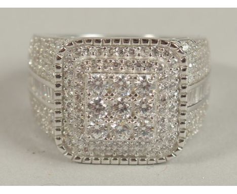 A SQUARE CHECKERBOARD-STYLE SILVER GENT'S RING set with round and baguette white cubic zirconia.