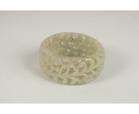 A PIERCED CELADON JADE BANGLE. 7cms diameter.