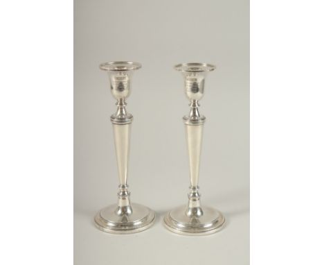 A PAIR OF SILVER CIRCULAR CANDLESTICKS on circular bases. 23cms high.