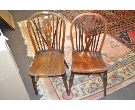 Two Victorian stick back kitchen chairs with elm seats and turned legs, one with a pierced back slat, the other with wheel de