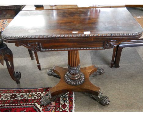 An early 19th Century rosewood card table, the top with red baize lining set on a fluted column with platform base and carved