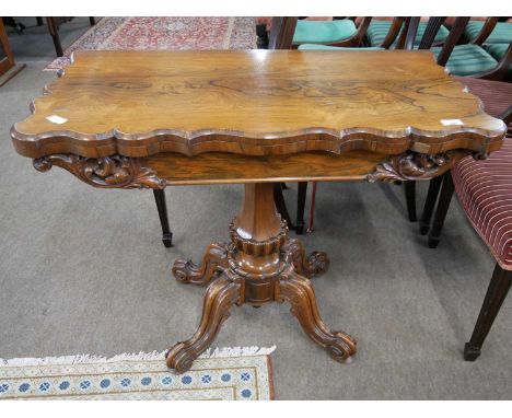 Victorian rosewood veneered card table with hinged revolving top over a tapering and carved column and four scrolled feet, 91