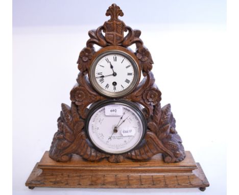 A late Victorian desktop clock and barometer set, in a carved oak case, 43 cm high