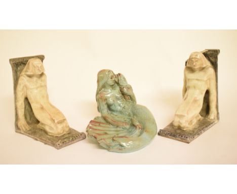 A pair of Emile Monier pottery bookends, in the form of Art Deco figures, and a pottery soap dish, in the form of a mermaid, 