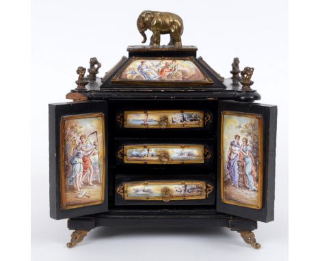 A 19th century Vienna enamel table casket, the elephants surmount above panels decorated classical figures and putto, the pan