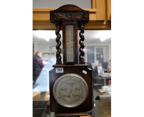 A 20th century oak cased barometer with barley twist supports.