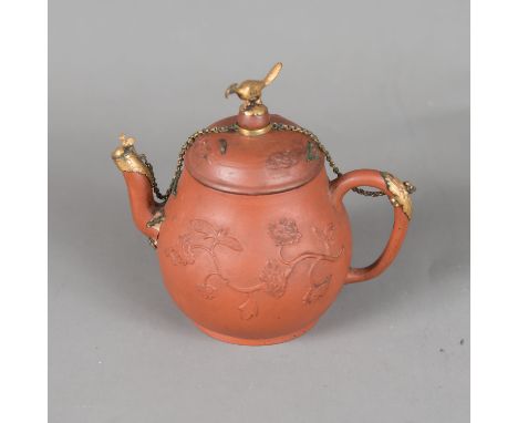 Yixing Tea Pot, in pear shape with spout, handgrip and lid. Decorated in half relief with flowers. Gilded bronze. Bird finial