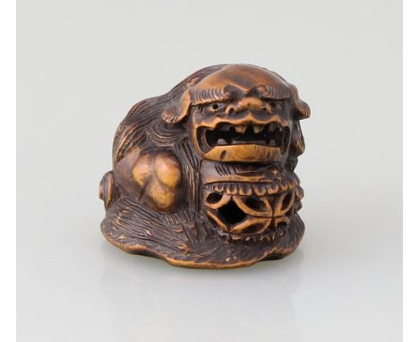 Netsuke "Kara shishi"Buchsbaum vollrund geschnitzt (katabori), hockender Shishi mit durchbrochen gearbeiteter Kugel auf flach