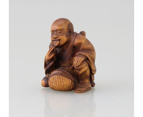 Netsuke "Samurai"Buchsbaum vollrund geschnitzt (katabori), graviert und schwarz eingefärbt (sumi), hockender Samurai an seine