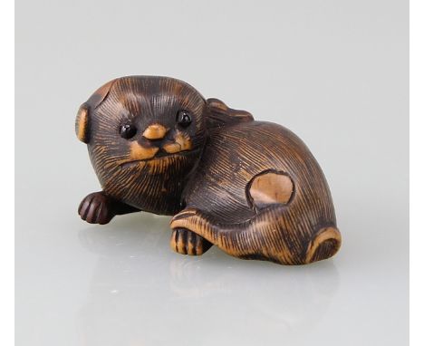 Netsuke "Liegender Welpe"Buchsbaum vollrund geschnitzt (katabori) und graviert mit eingelegten Augen in dunklem Horn, liegend