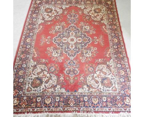 A Persian carpet, with a central medallion, 370 x 280cm, on a red field