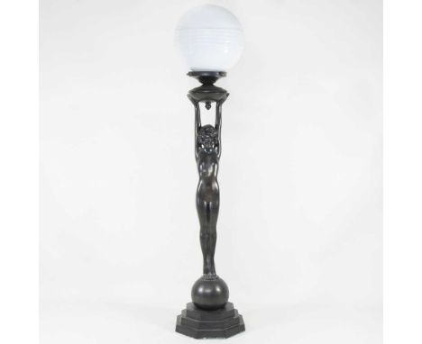 A large Art Deco style figural table lamp, with an opaque glass globe shade, 95cm high